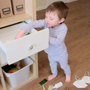 A happy child exploring a cabinet drawer with curiosity and wonder - Satawa Law, PLLC